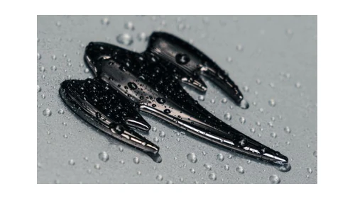 Koenigsegg ghost logo: a black ghost badge on a wet rear hood, seen at an angle